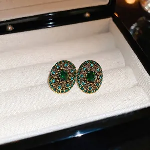 Vintage emerald oval earrings with blue crystals in a luxury jewelry box setting