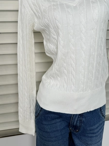 Detailed view of the white cable-knit texture and V-neck design of this slim sweater