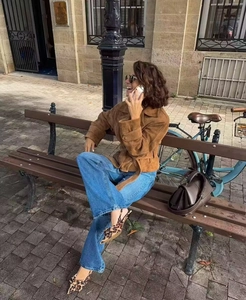 Chic brown suede jacket with waist tie and blue wide-leg jeans in an urban street setting