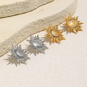 Detail of sun and crescent moon stud earrings with crystals in gold and silver finish