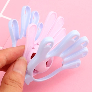 Macro detail of macaron plastic hand clapper toy showing pink and purple internal structure