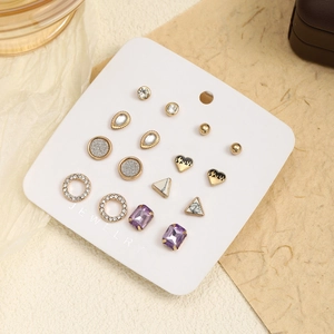 Detailed set of 9 pairs golden stud earrings featuring crystals, marble and heart motifs