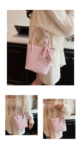 Detailed view of pink woven tote bag with silk scarf handle and crossbody strap
