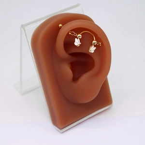 Detailansicht eines goldenen Schmetterlings-Industrial-Piercings am Ohrmodell