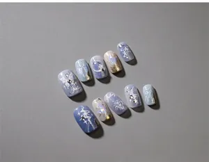 Detail of 3D butterfly nail charms and silver glitter on icy blue press-on nails