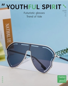 Detail of silver oversized sunglasses with one-piece blue lens and futuristic frame