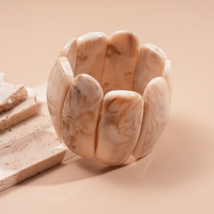 Macro detail of acrylic marble texture bracelet with beige and brown resin segments