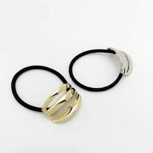 Detail of gold and silver hollow metal hair ties with triple-bar pattern on white background