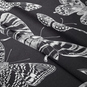 Close-up of bohemian butterfly pattern on soft textured black decorative wall tapestry