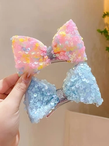 Close-up of glitter mermaid hair clips with colorful sequins and silver glitter center