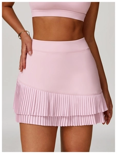 Detail of high waist pink pleated sports skirt featuring layered hem for tennis and golf