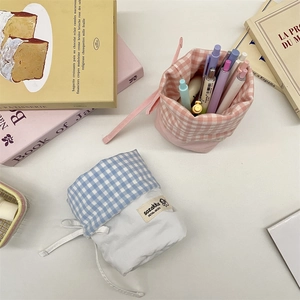 Detail of blue and pink plaid drawstring pencil pouches with soft cotton fabric texture