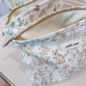 Floral cotton makeup bag with rabbit prints and zipper closure for women in cream white