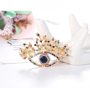 Detailed shot of an evil eye brooch with colorful rhinestones on a ceramic hand base