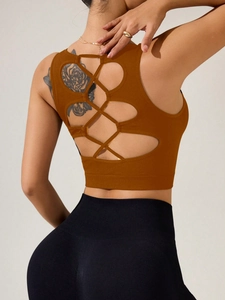 Vue macro du débardeur yoga orange avec design sophistiqué à lanières croisées au dos