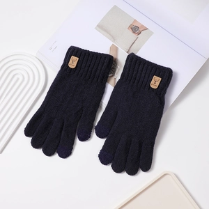 Détail de gants en tricot bleu marine avec doigts tactiles et étiquette en cuir