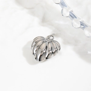 Macro detail of a silver pumpkin-shaped metal pendant charm for DIY jewelry making