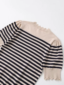 Detail of striped knit top showing scallop lace edges and delicate fabric texture