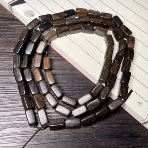 Macro shot of dark brown wooden barrel beads arranged on a traditional calligraphy book