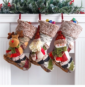 Close-up of three decorative Christmas stockings with 3D reindeer and Santa hung on a fireplace