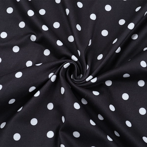 Gros plan d'un tissu tricoté à pois montrant la texture et des drapés en spirale