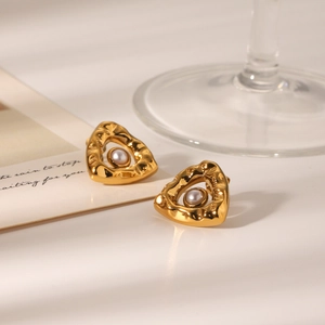 Golden triangle hammered steel stud earrings with central pearl on minimalist background