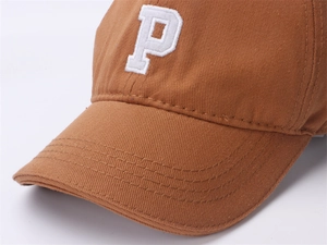 Detailed close-up of brown cotton baseball cap featuring embroidered white letter P
