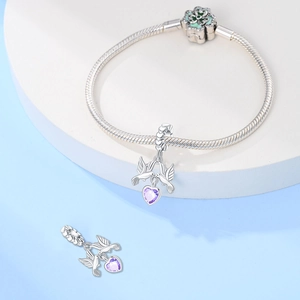 Dettaglio del ciondolo uccello placcato argento con zircone cuore viola sul bracciale