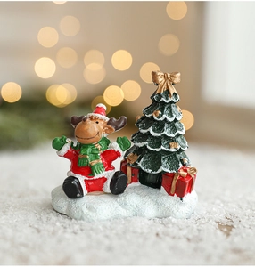 Detailed close-up of resin reindeer and Christmas tree miniatures on a snowy surface