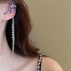 Detail of silver butterfly ear cuff featuring long tassel chains and faux pearls