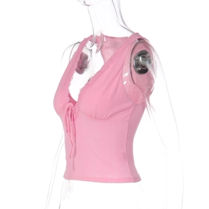 Dettaglio del gilet rosa con scollo a V, trama a costine e bordi in pizzo fine
