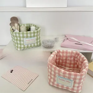 Close-up of pink and green quilted plaid storage baskets with soft fabric texture