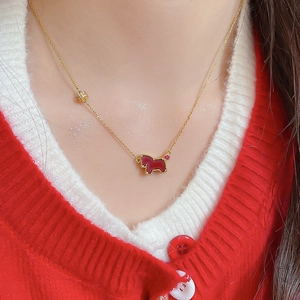 Close-up of model wearing a gold necklace with a red horse pendant and zircon detail