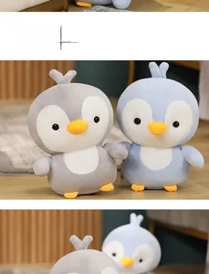 Detailed view of plush penguin toys in grey and blue with soft fabric and heart decor