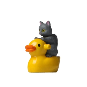 Miniature figurine of a cute grey cat riding a yellow rubber duck for garden decor