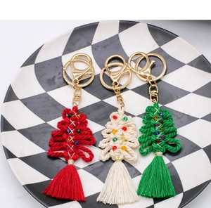 Close-up of handmade woven cotton Christmas tree keychains with beads and tassels