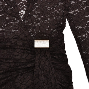 Detailed macro view of black lace fabric with floral texture and gold metal waist buckle