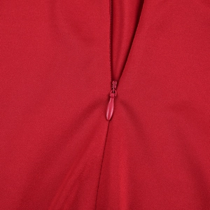Nahaufnahme des unsichtbaren Reißverschlusses am roten, langärmeligen Faltenkleid