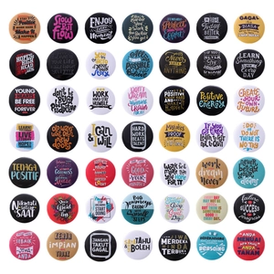 Set of 49 colorful round tinplate badges with motivational quotes in a grid layout