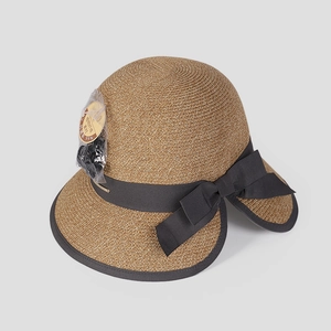 Detail of brown straw sun hat featuring a large black bow and UV protection tag