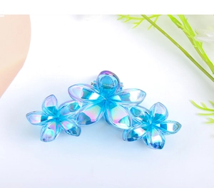Iridescent blue plumeria hair claw clip with a three-flower acrylic gradient design