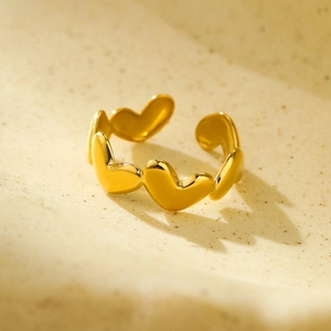 Macro shot of 18k gold irregular heart-shaped open ring with polished metal finish