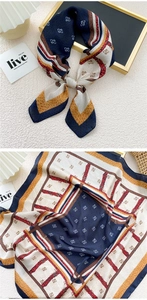 Detail of silk scarf with navy belt buckle print and elegant geometric patterns