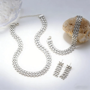 Detailed close-up of a silver watch-band style chain jewelry set with necklace and earrings