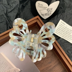 Pinza per capelli a farfalla in acetato con cuori traforati in tartaruga blu marmorizzata
