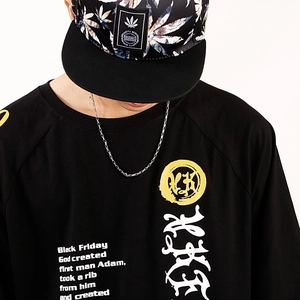 Close-up of a street style black t-shirt with poetry text and a silver box chain necklace