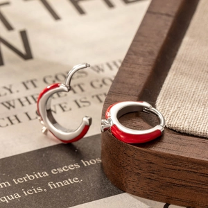 Orecchini in argento con design a mela in smalto rosso su sfondo vintage