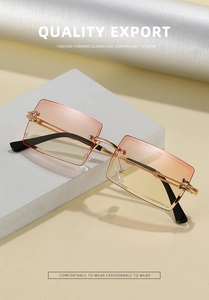 Detail of rimless rectangle sunglasses featuring pink-orange gradient lenses and gold temples