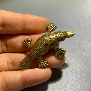 Detailed macro view of vintage brass platypus figurine with realistic hair texture