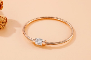 Gros plan du bracelet chaîne serpent en or rose avec perle cylindrique sertie de cristaux